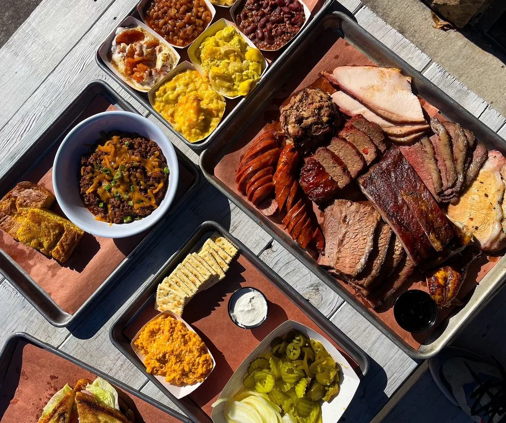 A Fire Craft spread of smoked meats and sides on an outdoor table