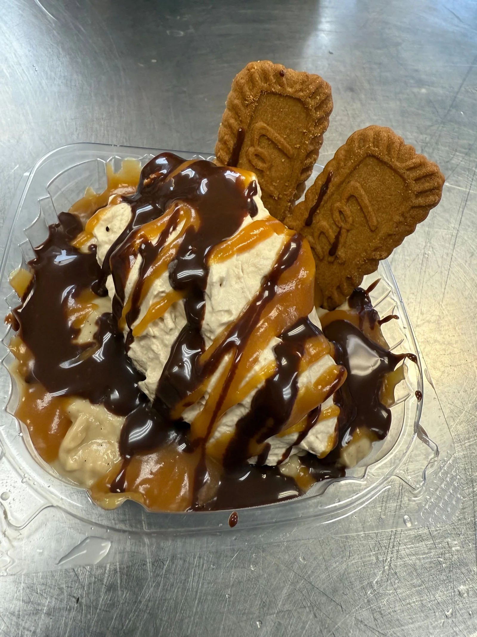 An ice cream sundae with sauce and cookies