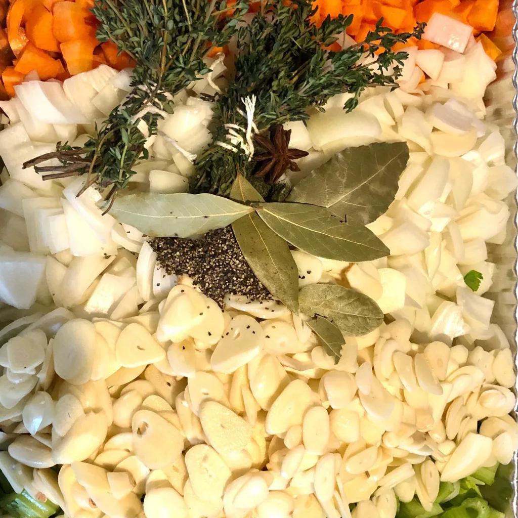 Chopped carrots, onions and garlic with fresh herbs, bay leaves and spices