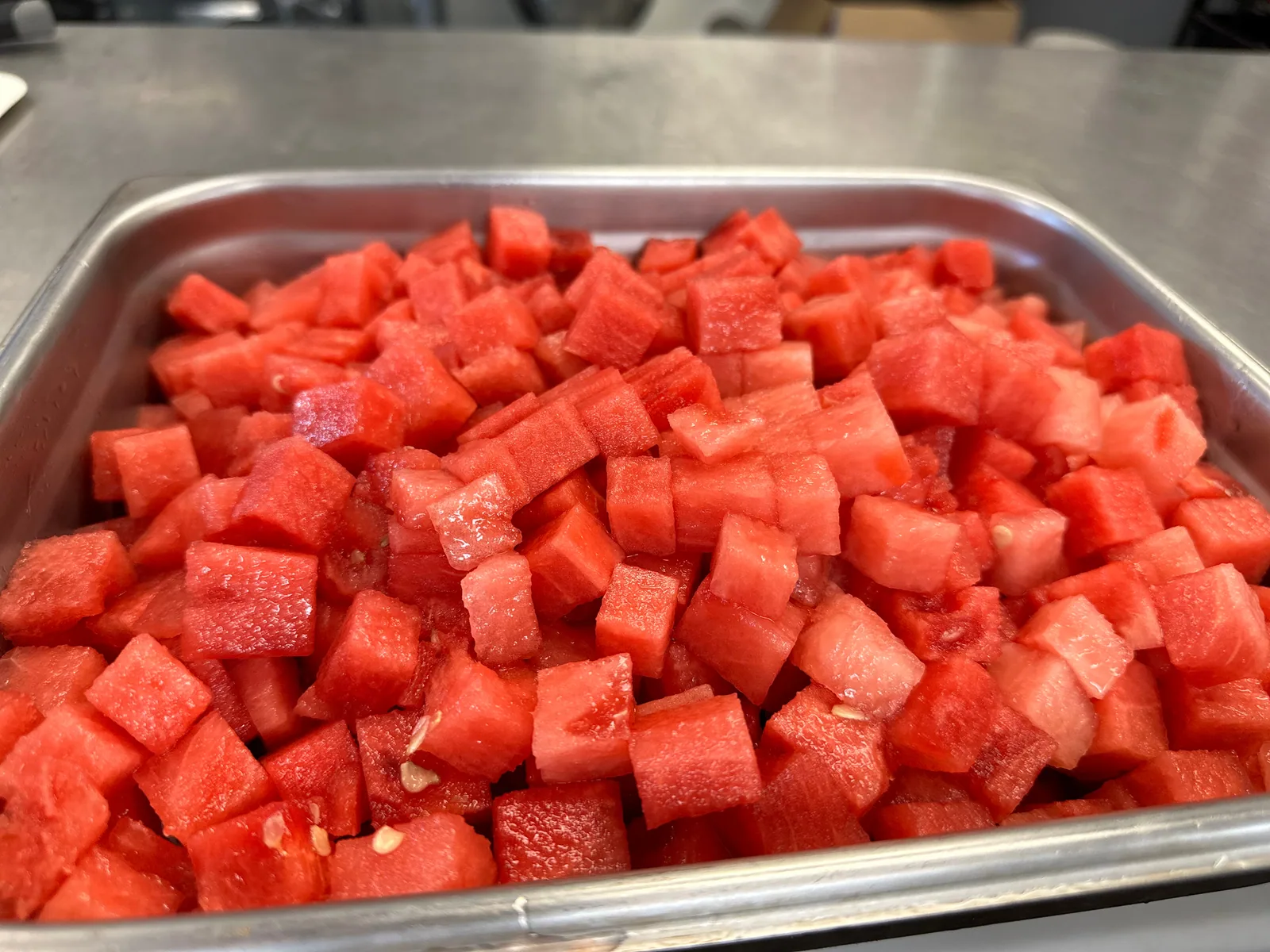 A tray of freshly cut red watermelon cubes